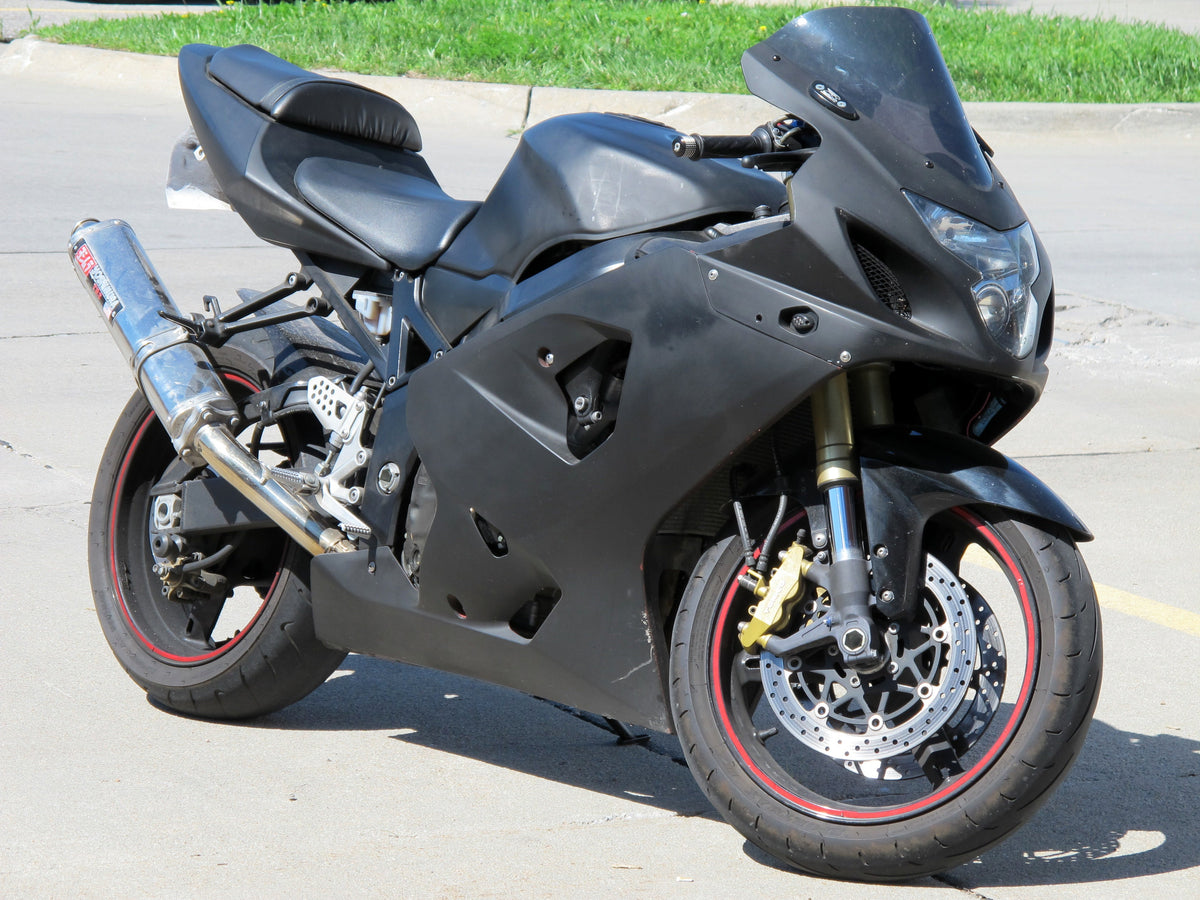 Black customized Suzuki GSX-R 750 motorcycle parked outdoors, viewed from the front-right side