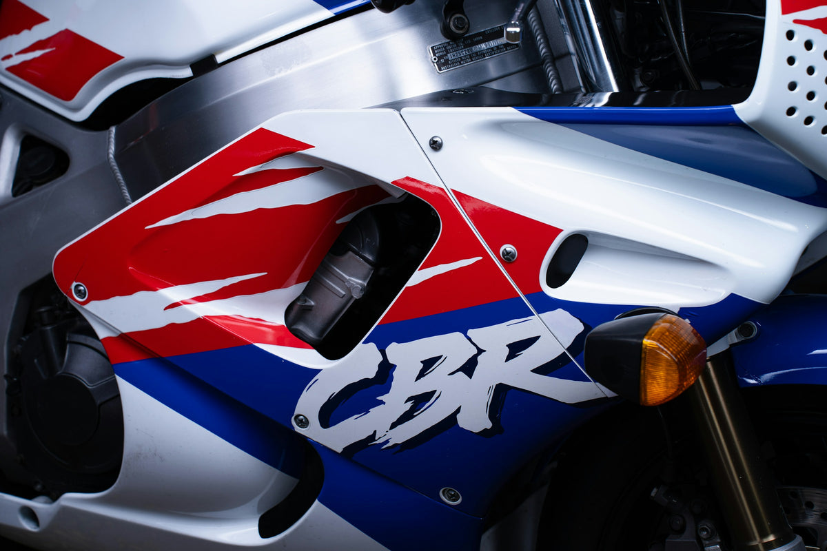 Close-up of white red and blue Honda motorcycle fairing panels and fasteners