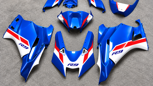 Owner-provided blue, white and red YZF-R9 fairing-panel flat lay, AI-reframed for a wide cover; appearance reference only, not a packing list or aero-fitment proof