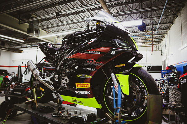 Real faired BMW race motorcycle in a working garage; editorial context, not the scuffed used bike or a NiceFairings customer project