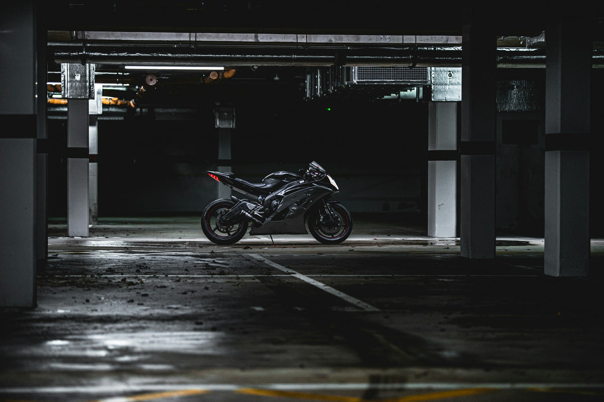 Black fully faired Yamaha R6 parked in a dark concrete garage, used as real editorial context for motorcycle cover fit and winter storage planning