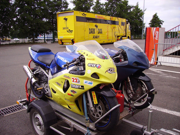 Two Suzuki GSX-R sportbikes sharing a small trailer at Magny-Cours, France; real 2009 editorial photograph, not a NiceFairings product.