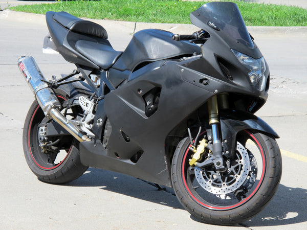 Black customized Suzuki GSX-R 750 motorcycle parked outdoors, viewed from the front-right side