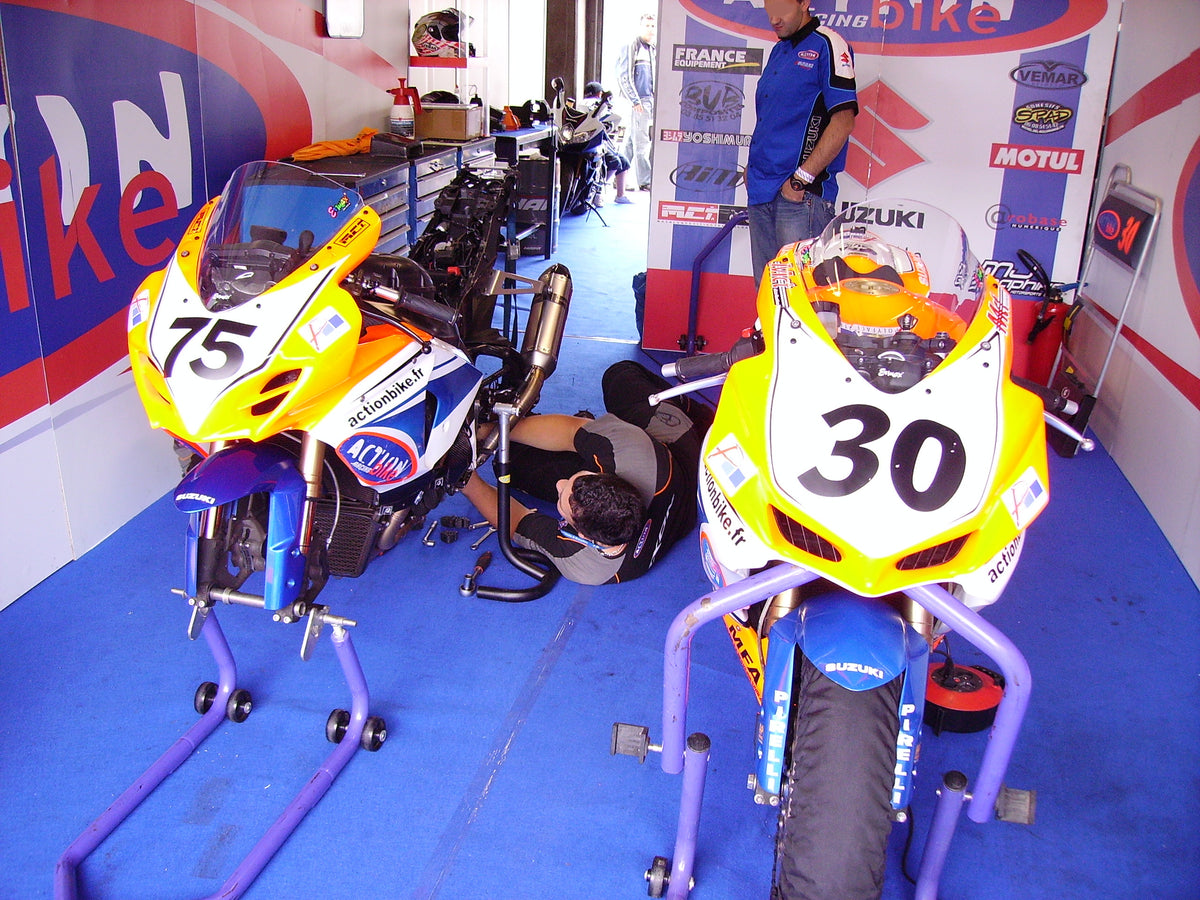 Real Suzuki GSX-R sportbike undergoing pit repair with fairing partially removed; editorial context, not claim evidence or a NiceFairings product