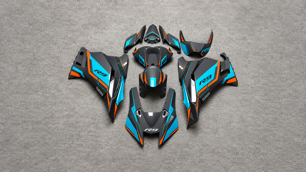 Complete black, cyan and orange YZF-R9 fairing-panel flat lay supplied by the owner, with gray floor AI-extended at the sides; no slider fitment is demonstrated