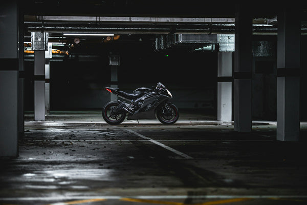 Black fully faired Yamaha R6 parked in a dark concrete garage, used as real editorial context for motorcycle cover fit and winter storage planning