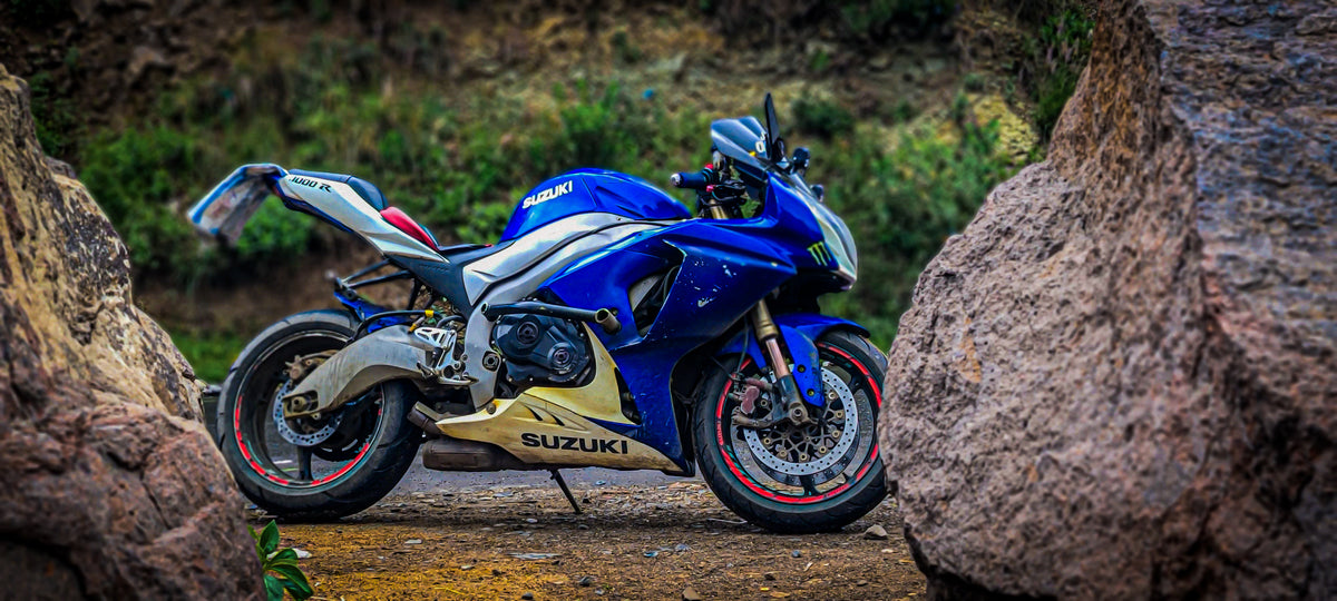 Real Suzuki GSX-R1000 parked outdoors between rock formations, photographed by Fuad Al-Qrize under CC BY 4.0; a pre-project appearance reference, not a winter scene or NiceFairings installation